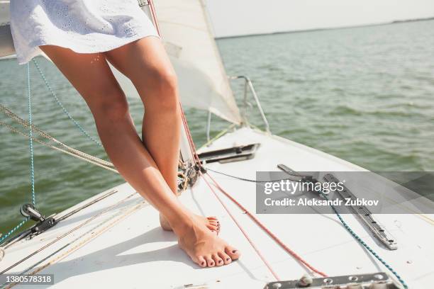 woman legs wearing fashionable dress and high heels summer shoes. female walking on sea coast. yachts in the background - beautiful legs in high heels stock pictures, royalty-free photos & images