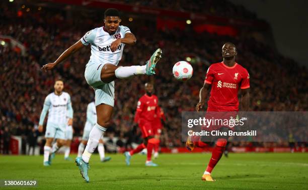 Ben Johnson of West Ham United is challenged by Sadio Mane of Liverpool during the Premier League match between Liverpool and West Ham United at...