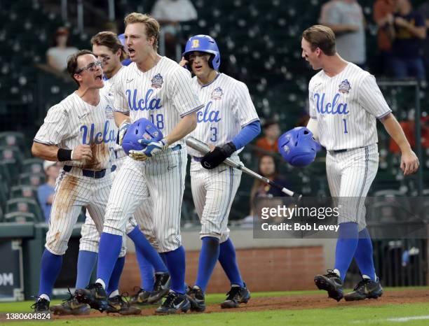 Carson Yates of the UCLA Bruins celebrates with his teammates after hitting a grand slam in the first inning against the Oklahoma Sooners during the...