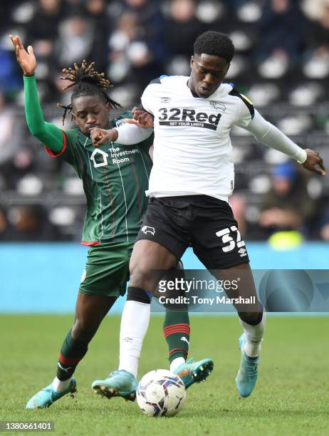 Malcolm Ebiowei of Derby County is challenged by Domingos Quina of Barnsley during the Sky Bet Championship match between Derby County and Barnsley...