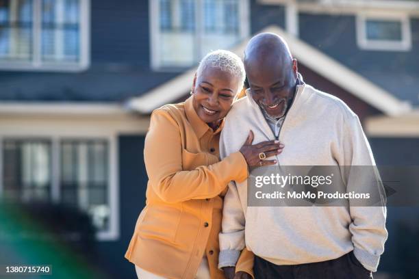 senior couple couple walking in front of their home - 歩く　カップル ストックフォトと画像