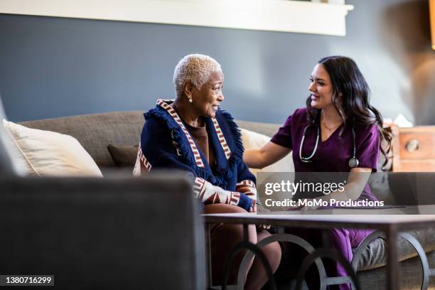 nurse doing in home consultation with senior woman - senior care stock pictures, royalty-free photos & images