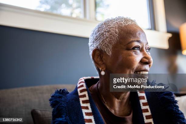 portrait of senior woman in her home - african ethnicity stock-fotos und bilder