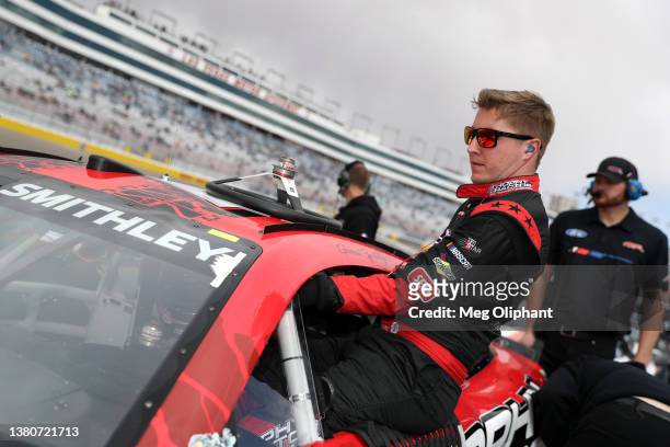 Garrett Smithley, driver of the Trophy Tractor Ford, enters his car during qualifying for the NASCAR Cup Series Pennzoil 400 at Las Vegas Motor...