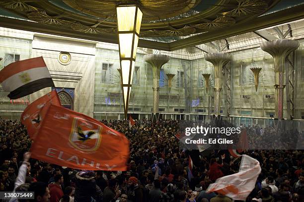 Family members and mourners gather at Cairo's railway station as they receive the bodies of 74 football fans who were killed during clashes between...