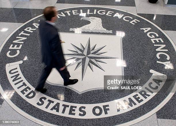 Man crosses the Central Intelligence Agency logo in the lobby of CIA Headquarters in Langley, Virginia, on August 14, 2008. AFP PHOTO/SAUL LOEB