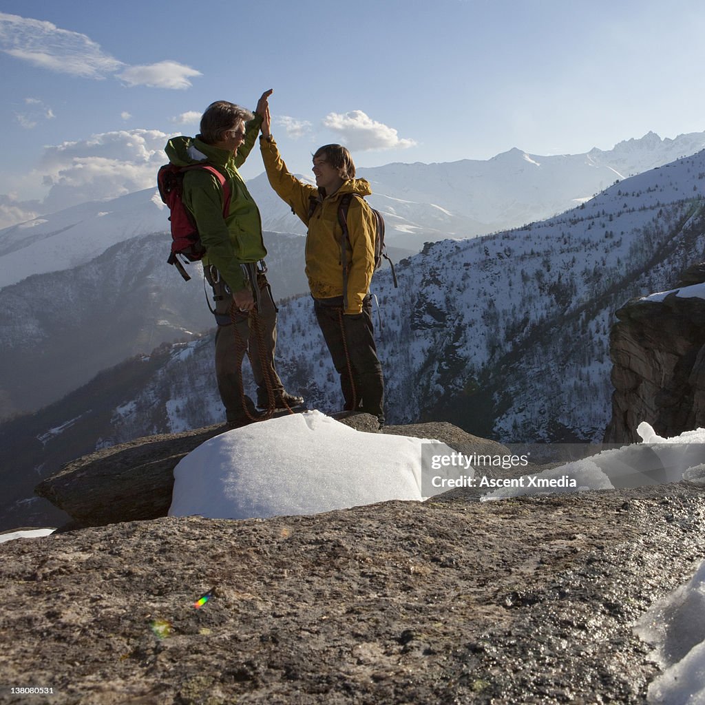 Father and son exchange "high-fives" on summit