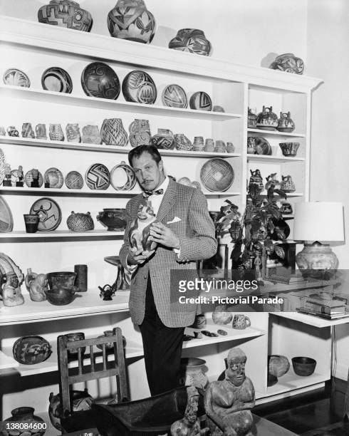 American actor Vincent Price with a display of ceramics from his art collection, circa 1955.