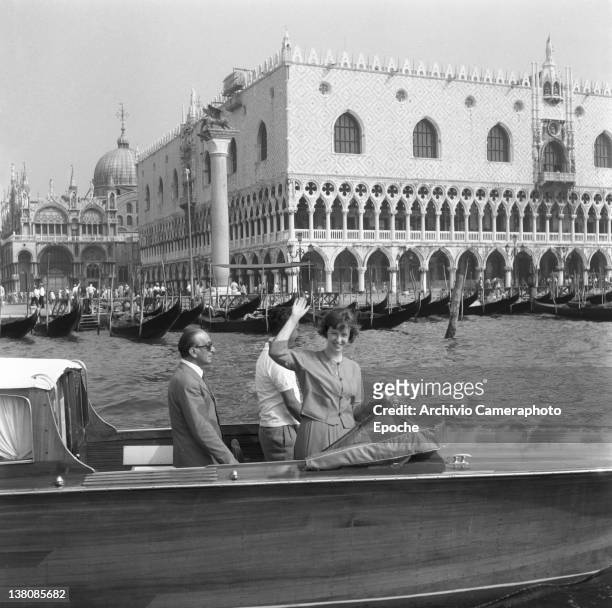 American actress Betsy Blair portrayed while waving from a water taxi, St Mark Square in the background, Venice, 1960.