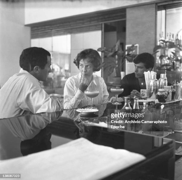 American actress Betsy Blair sitting at a bar counter, portrayed while having a drink, Lido, Venice, 1960.