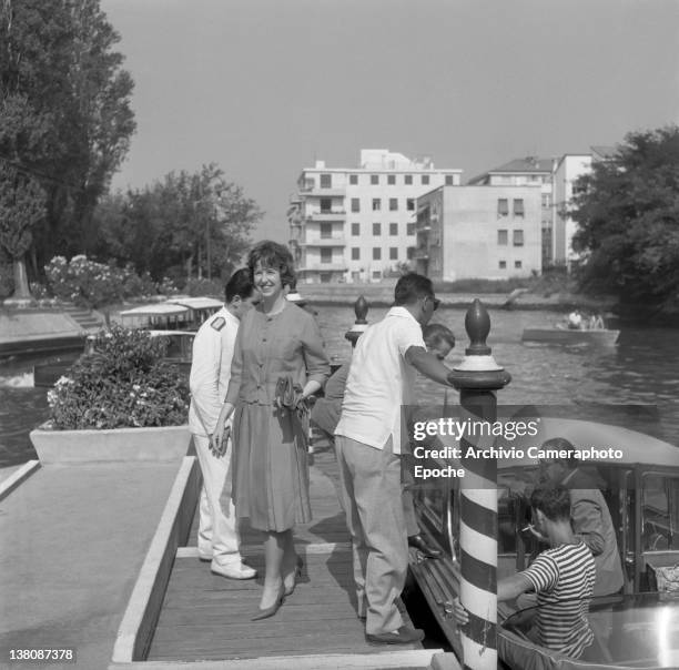 American actress Betsy Blair standing on a pier after getting down a water taxi, Lido, Venice, 1960.