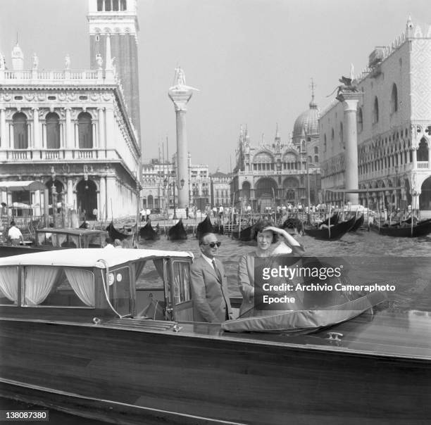American actress Betsy Blair portrayed on a water taxi, St Mark Square in the background, Venice, 1960.