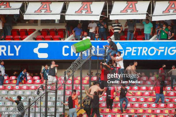 Fans of Atlas and Queretaro fight in the stands during the 9th round match between Queretaro and Atlas as part of the Torneo Grita Mexico C22 Liga MX...