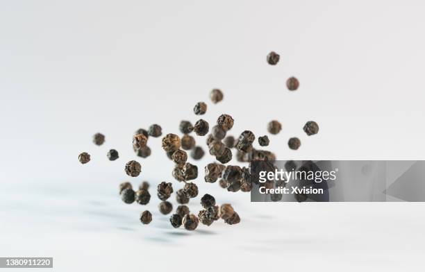 black pepper flying in mid air in white background - bounce bildbanksfoton och bilder