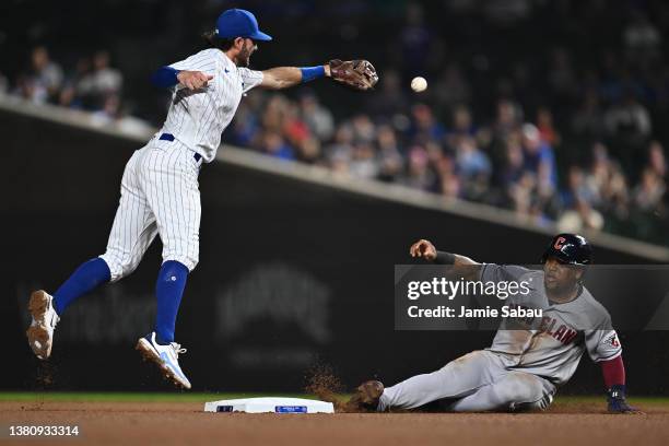 Jose Ramirez of the Cleveland Guardians slides safely in to second base as the throw sails past Dansby Swanson of the Chicago Cubs in the sixth...