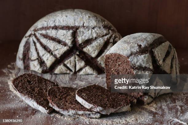 bread of art. dutch oven no knead rustic rye bread with origami crease pattern scored atop. sliced - rye bread stock pictures, royalty-free photos & images