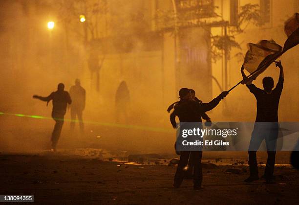 Protesters run through clouds tear gas fired by security forces February 2, 2012 in Cairo, Egypt. The protest follows the deaths of 74 football fans...