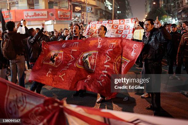 Protesters hold an Al Ahly football club flag during a march to the interior ministry after a demonstration outside Cairo's Al Ahly football stadium...