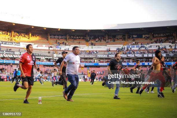 Fans of Atlas run on to the pitch during the 9th round match between Queretaro and Atlas as part of the Torneo Grita Mexico C22 Liga MX at La...