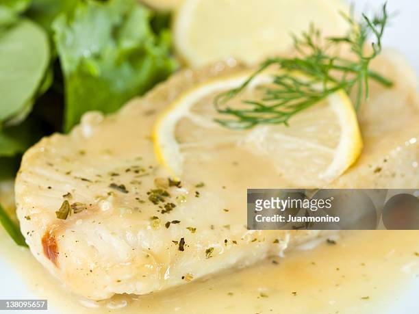 white fish fillet in lemon and herbs sauce - hake stock pictures, royalty-free photos & images