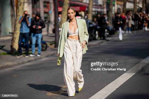 Leonie Hanne seen wearing mint green blazer, Hermes bag, creme white latte wide leg pants, cropped top, neon heels outside Hermes during Paris...