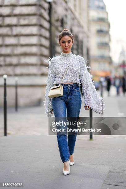 Heart Evangelista wears silver and rhinestones earrings, a gray embroidered crystal and rhinestones with feathers long puffy sleeves high neck...