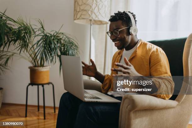 young african american using laptop on sofa - excitement laptop stock pictures, royalty-free photos & images