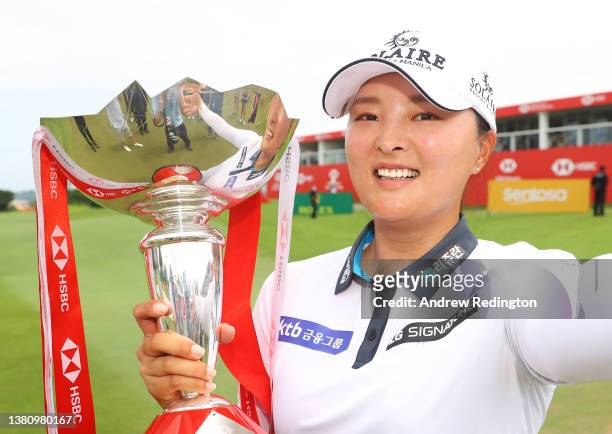 Jin Young Ko of South Korea imitates a “selfie” as she poses with the trophy after winning during the Final Round of the HSBC Women's World...
