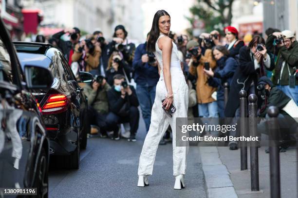 Maeva Marshall wears brown sunglasses, a white pearls large necklaces from Vivienne Westwood, a white V-neck corset tank-top, white pearls bracelets...