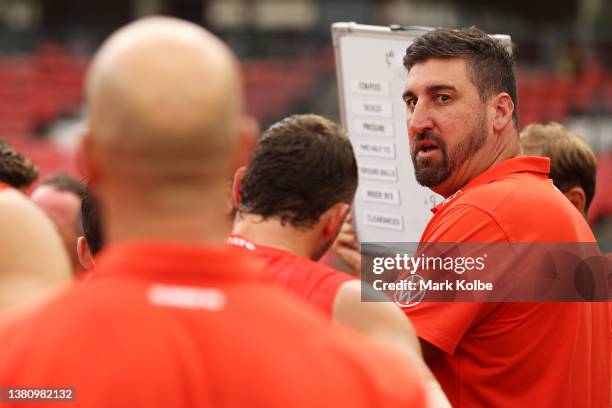 Swans asistant coach Dean Cox speaks ton the team at three quarter time during the AFL AAMI Community Series match between the Sydney Swans and the...