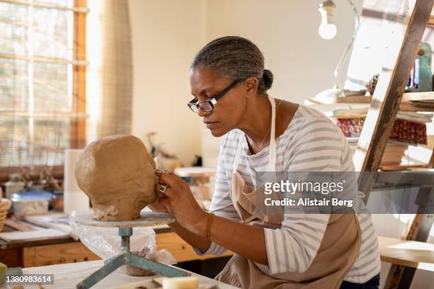 female sculptor working in her art studio - black sculptor stock pictures, royalty-free photos & images