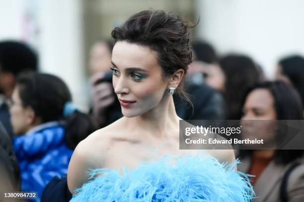Mary Leest wears silver and rhinestones earrings, a blue oversized embroidered feather shoulder-off top, outside Elie Saab , during Paris Fashion...