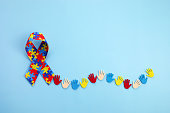 Autism awareness concept with colorful hands on blue background. Top view