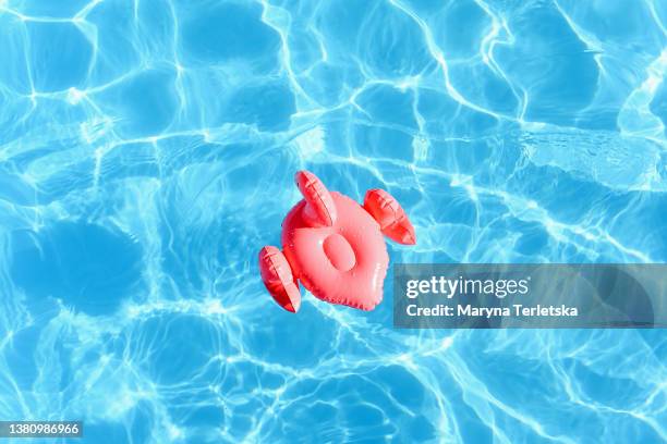 swimming circle in the form of a pink flamingo in the pool. swimming pool. summer vacation. rest. blue water. swimming in the pool. vacation. hot weather. pink flamingo. swimming. swim circle. - buitenbad stockfoto's en -beelden