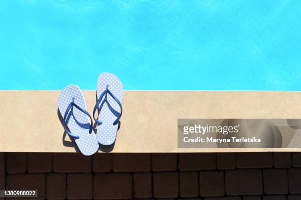 blue flip flops stand on the side of the pool. blue flip flops with polka dots. hot summer. summer footwear. summer. rest around the pool. - beach flat lay stock pictures, royalty-free photos & images