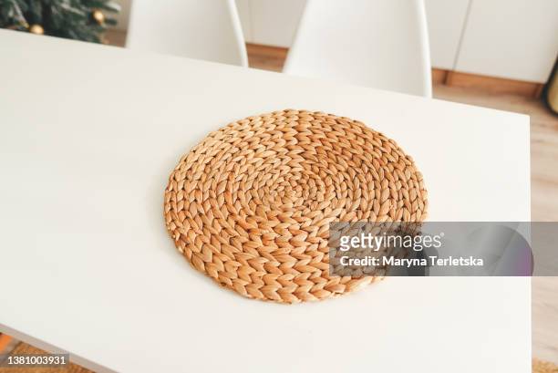 a jute rug lies on a white kitchen table. jute fiber rug. natural color. kitchen interior in light colors. woven rug. eco rugs for the kitchen. - wicker mat stock pictures, royalty-free photos & images