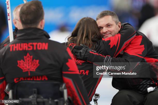 Mark Ideson of Team Canada embraces Ina Forrest of Team Canada after competing against team Latvia at the National Aquatics Center during day two of...