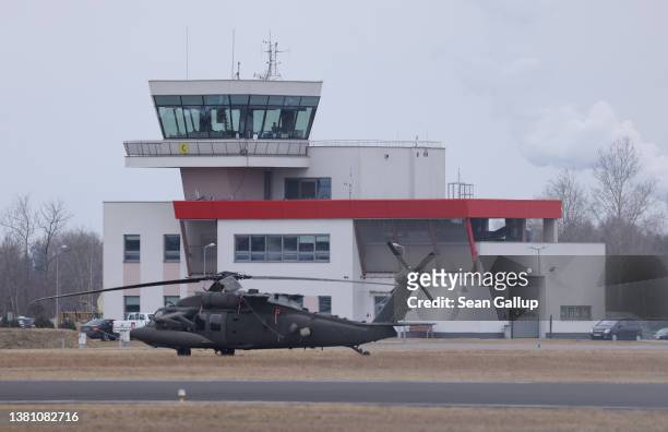 Black Hawk military helicopter of the U.S. Army stands near the control tower at an airfield currently being used by the Army's 82nd Airborne...