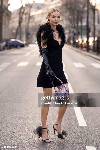 Leonie Hanne wearing a black mini dress with feathers sleeves, black Prada leather gloves, black Jimmy Choo sandals and Prada bag, is seen outside...