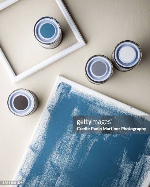 sealed paint cans, painted canvas and a white wooden frame - powder blue foto e immagini stock