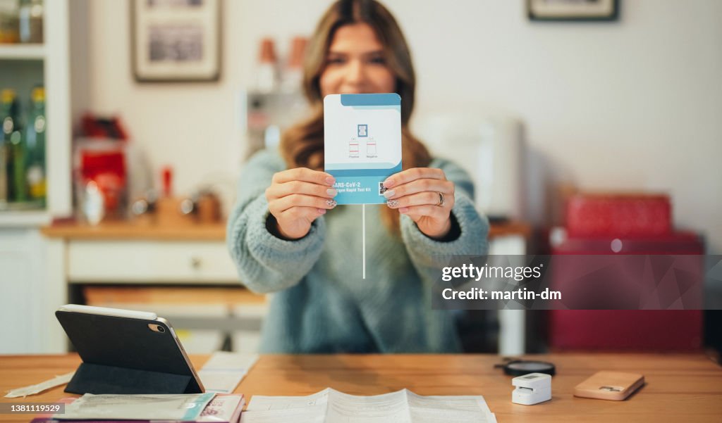 Young woman showing SARS-COV-2 OMICRON positive test result to the camera