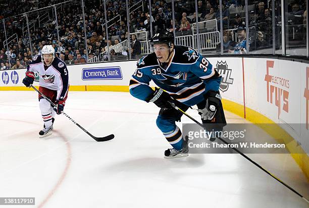 Logan Couture of the San Jose Sharks looks for control of the puck in front of Aaron Johnson of the Columbus Blue Jackets at HP Pavilion at San Jose...