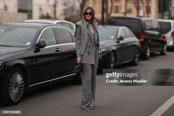 Darja Barannik seen wearing a grey wide leg pants, grey double breasted blazer, a grey pulloverm a black Ray Ban sunglasses and a brown Acne bag on...