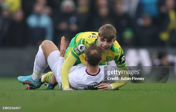 Brandon Williams of Norwich City hugs Christian Eriksen of Brentford after falling on top of him during the Premier League match between Norwich City...