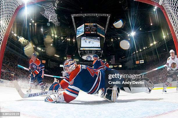 Devan Dubnyk of the Edmonton Oilers dives cross-crease to make a save against the Chicago Blackhawks at Rexall Place on February 2, 2012 in Edmonton,...