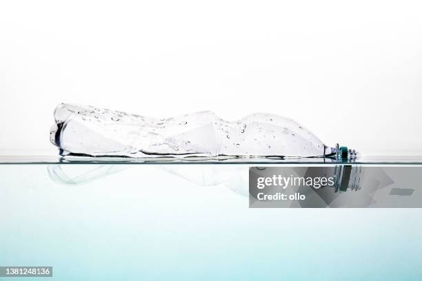 contaminación ambiental. botella de plástico vacía flotando en el agua - floating on water fotografías e imágenes de stock