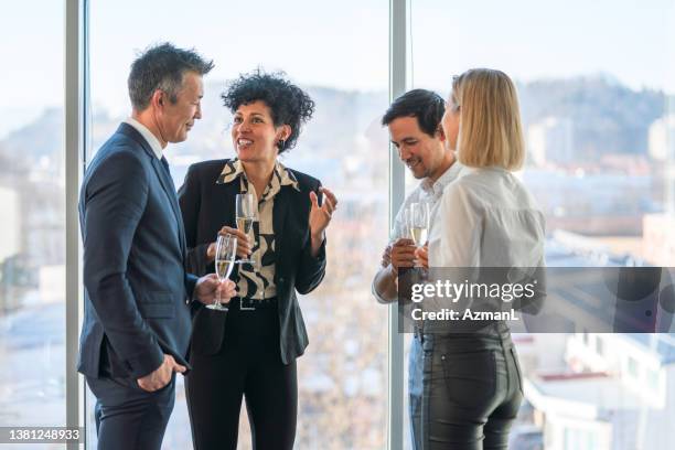 male and female executives enjoying champagne at the office party - lobba bildbanksfoton och bilder