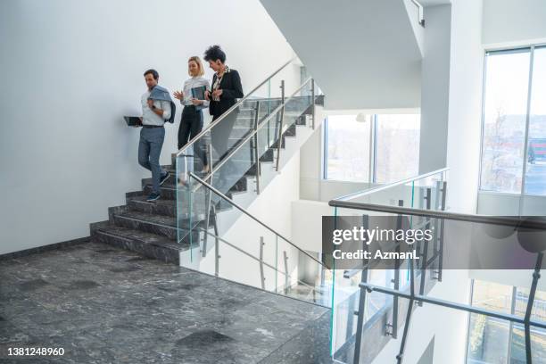 diverse group of business coworkers walking downstairs - political stock pictures, royalty-free photos & images