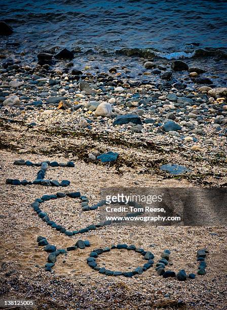 message in sand on beach - wowography stock pictures, royalty-free photos & images