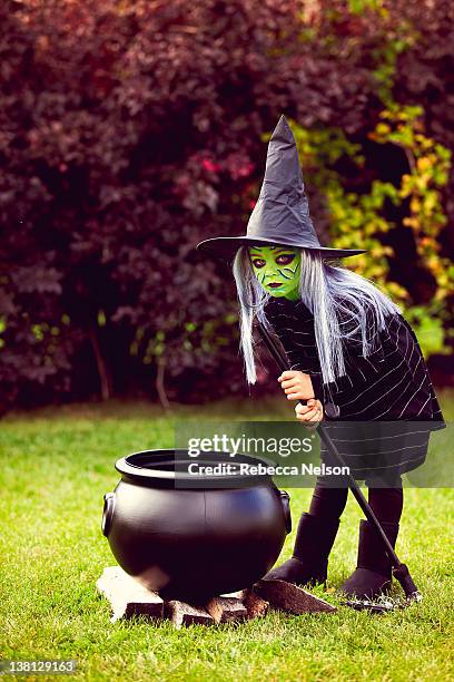 little girl dressed as witch with cauldron - marmite photos et images de collection